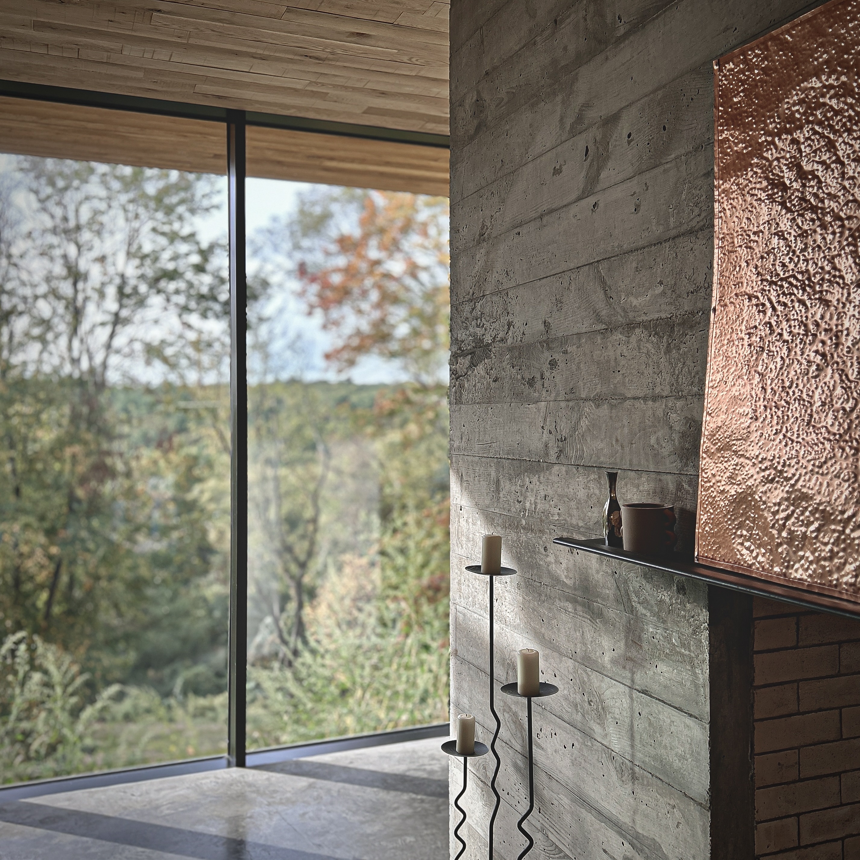 Living area with board-formed concrete wall, copper fireplace hood, and floor-to-ceiling glazing overlooking the Hudson Valley